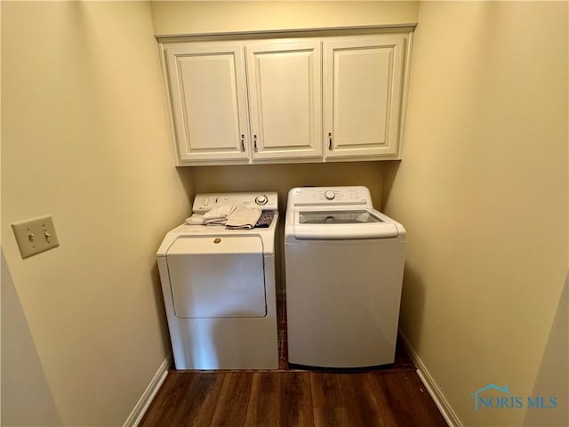 clothes washing area featuring cabinet space, baseboards, dark wood-style floors, and washer and clothes dryer