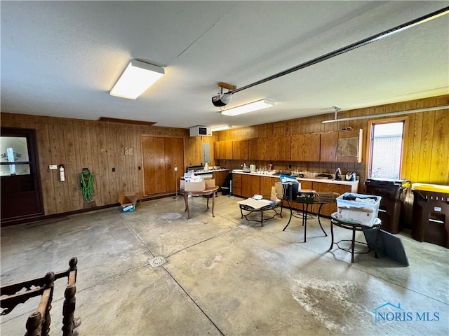 interior space featuring wood walls and a garage door opener