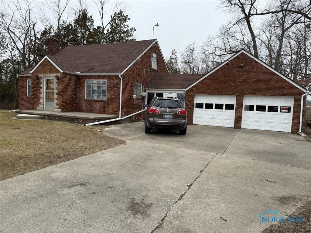 view of front of home featuring a garage, roof with shingles, brick siding, and a chimney