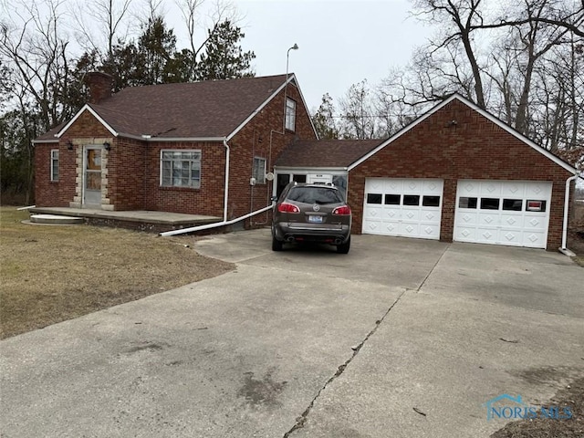 view of front of home with brick siding, a chimney, a garage, and a shingled roof