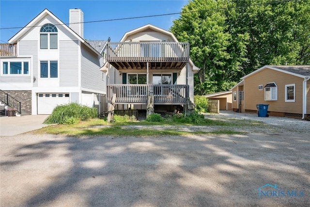 view of front of house featuring a garage, concrete driveway, and a chimney