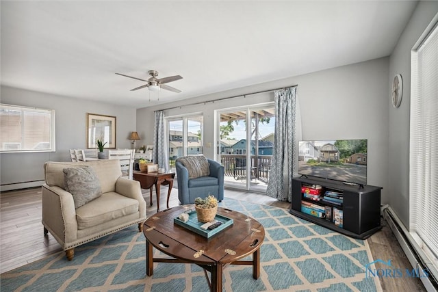 living area with a baseboard radiator, wood finished floors, and a ceiling fan