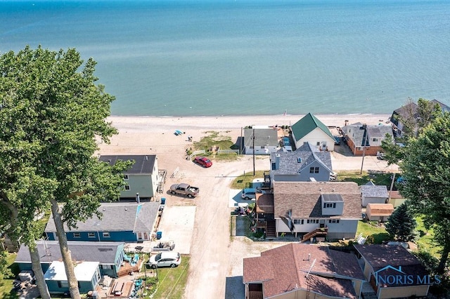 drone / aerial view with a water view, a residential view, and a beach view