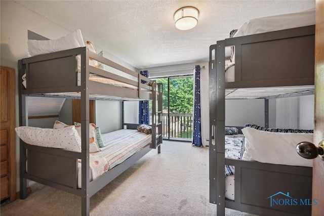 carpeted bedroom with access to exterior and a textured ceiling