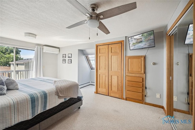 bedroom featuring access to exterior, a wall mounted AC, a baseboard heating unit, a textured ceiling, and baseboards