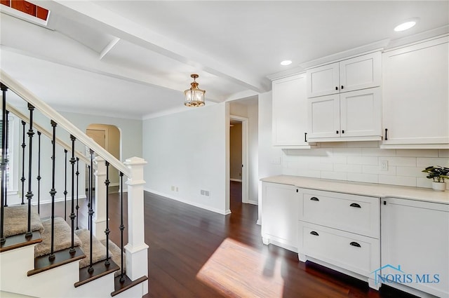 interior space featuring arched walkways, dark wood finished floors, stairs, recessed lighting, and baseboards