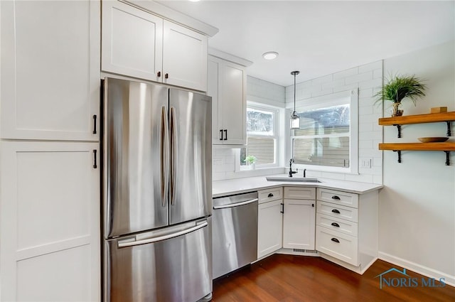 kitchen featuring light countertops, stainless steel appliances, dark wood-style floors, and a sink