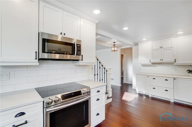 kitchen featuring light countertops, appliances with stainless steel finishes, white cabinets, and tasteful backsplash
