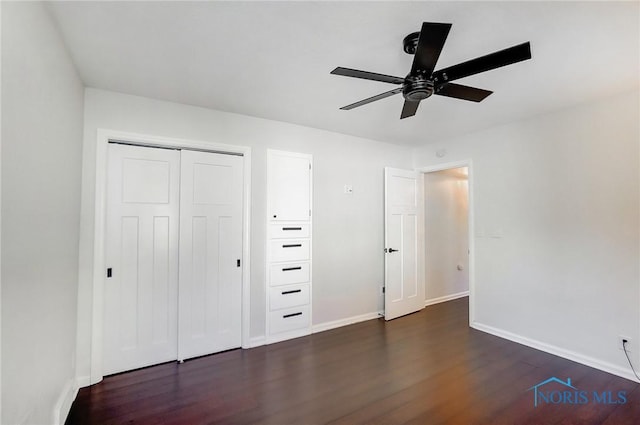 unfurnished bedroom with baseboards, dark wood-style floors, ceiling fan, and a closet