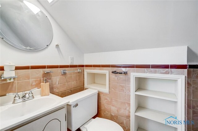 bathroom with tile walls, vaulted ceiling, and toilet
