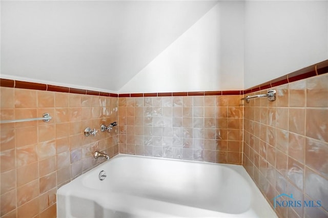 full bathroom featuring tile walls and a bath
