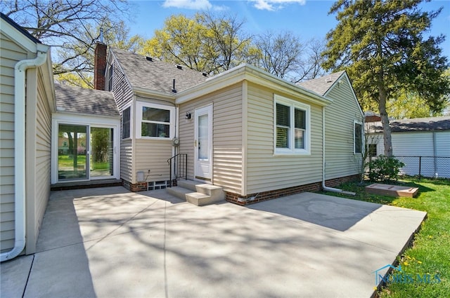 rear view of property featuring a patio, a shingled roof, fence, and entry steps
