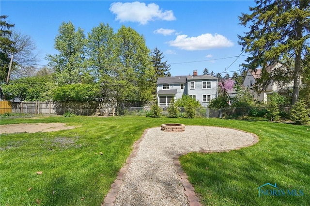 view of yard with a fenced backyard, a patio, and a fire pit