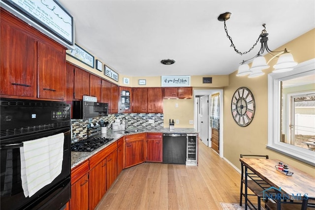 kitchen featuring wine cooler, tasteful backsplash, light wood-style floors, a sink, and black appliances