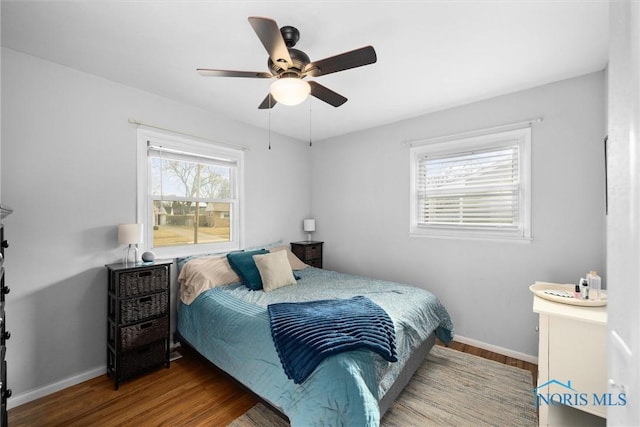 bedroom featuring ceiling fan, baseboards, and wood finished floors