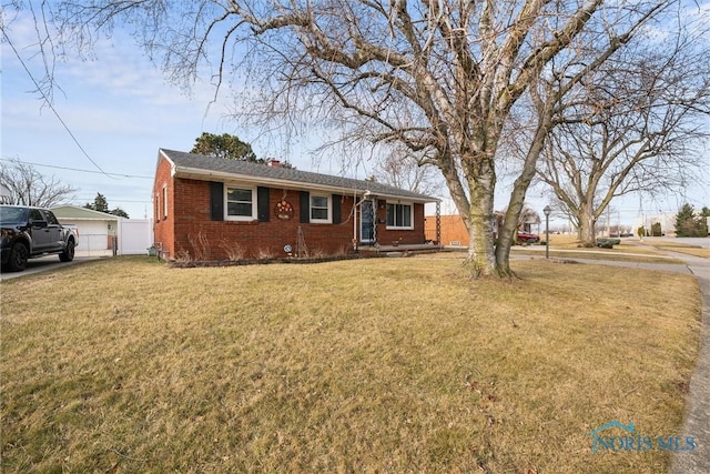 single story home featuring brick siding, a front lawn, and fence