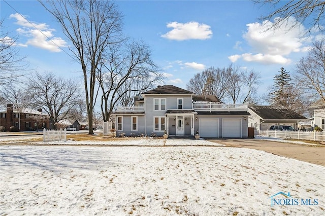 view of front of house with an attached garage, driveway, and fence