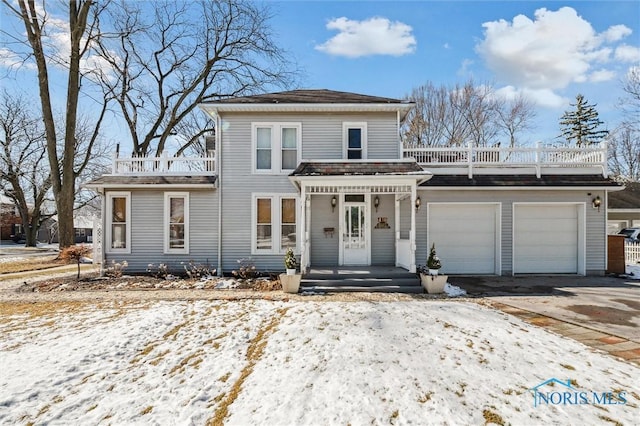 view of front of property featuring driveway, a balcony, and an attached garage