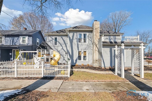 view of front of home featuring fence and a chimney