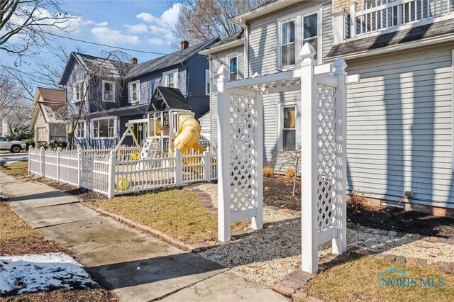 view of side of home featuring a residential view, a playground, and fence