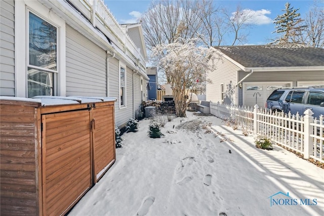 snow covered property with fence