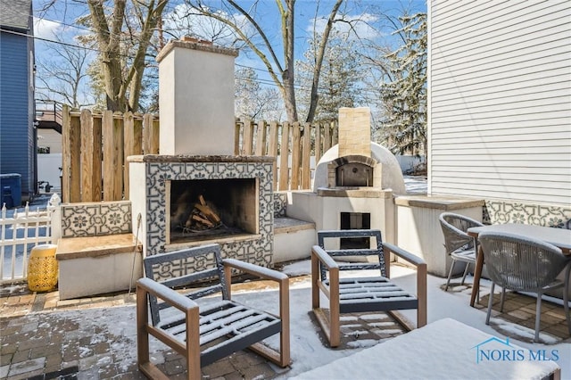 view of patio / terrace featuring an outdoor fireplace and fence