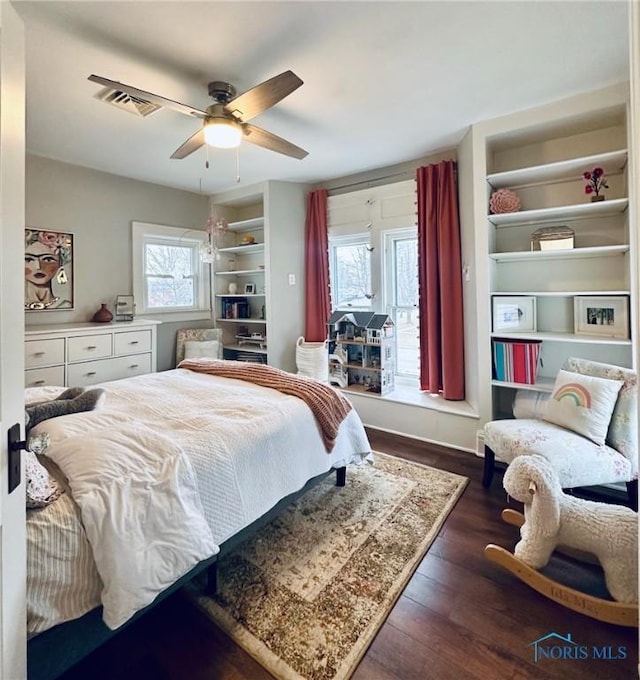 bedroom featuring ceiling fan, wood finished floors, and visible vents