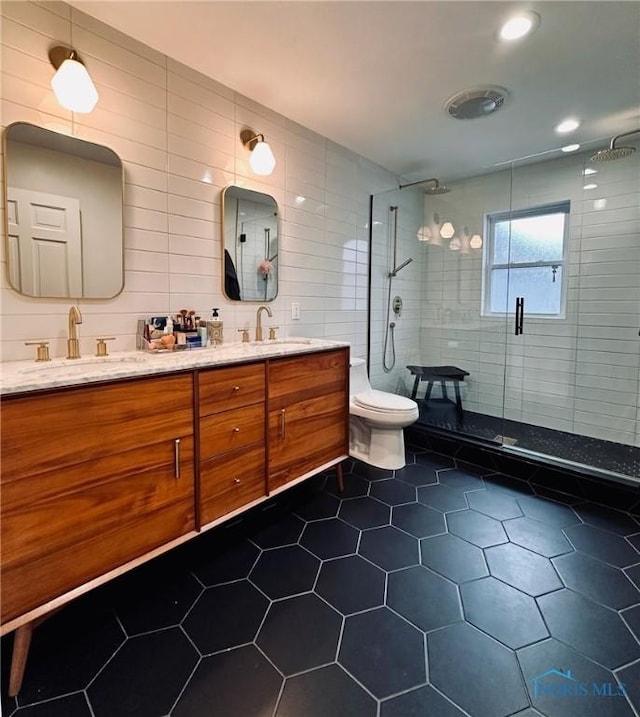 full bathroom featuring tile patterned flooring, a sink, toilet, and a shower stall