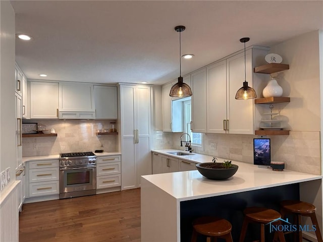 kitchen featuring dark wood-style flooring, open shelves, a sink, high end stove, and a peninsula