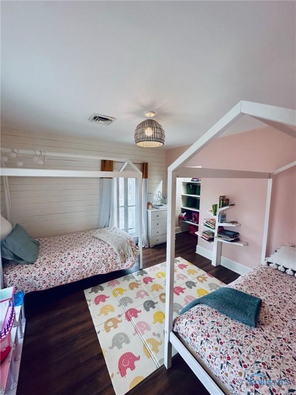 bedroom featuring wood finished floors, visible vents, and baseboards