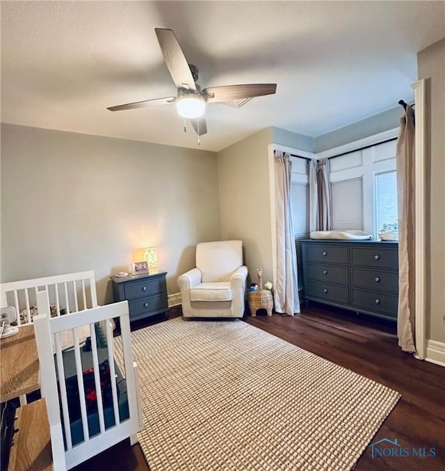 bedroom with a ceiling fan, dark wood finished floors, and baseboards