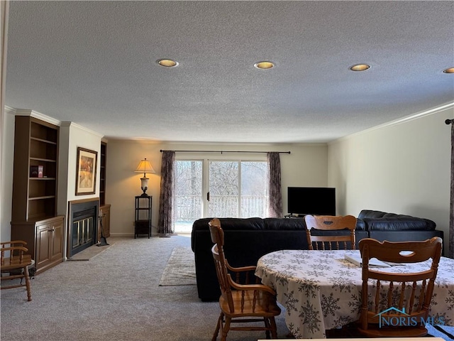 dining space featuring a fireplace with flush hearth, carpet flooring, crown molding, and a textured ceiling