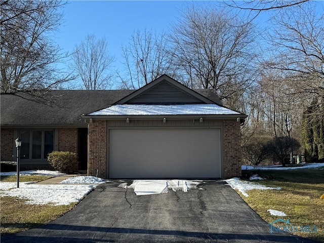 view of front facade with a garage, brick siding, and driveway