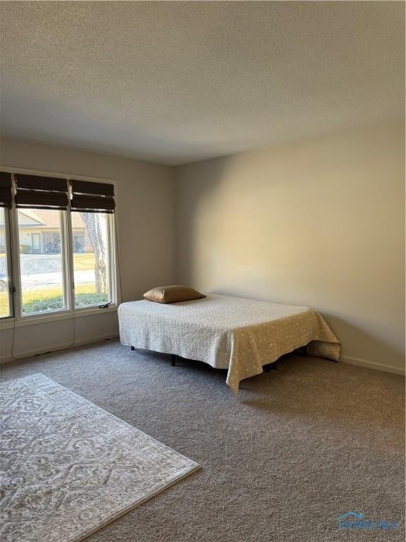 carpeted bedroom featuring a textured ceiling