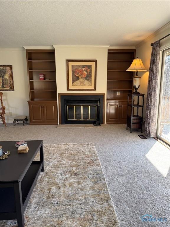 living room with a textured ceiling, carpet flooring, a fireplace with flush hearth, and crown molding