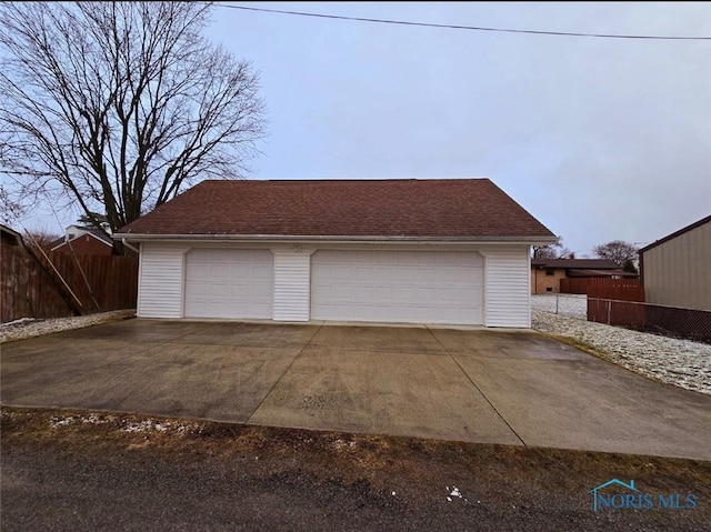 detached garage featuring fence