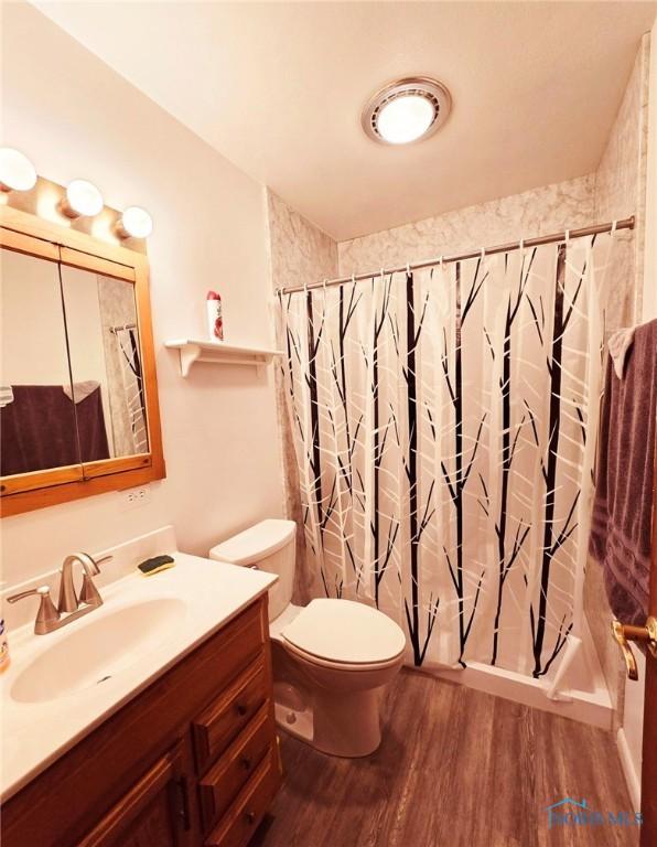 1934 Geffs Ave, Findlay, OH 45840 - bathroom featuring vanity, a shower with shower curtain, toilet, and wood finished floors