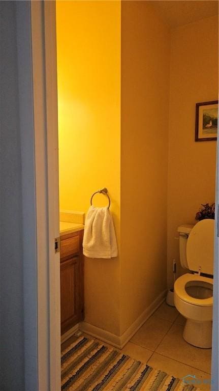 bathroom with tile patterned flooring, toilet, and baseboards