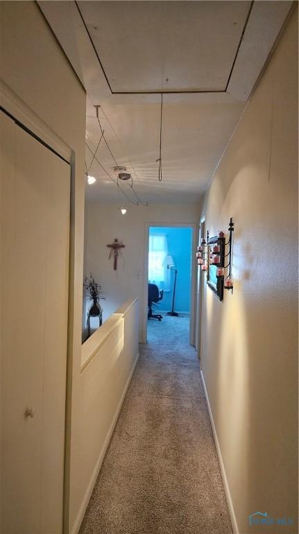 corridor featuring carpet and baseboards