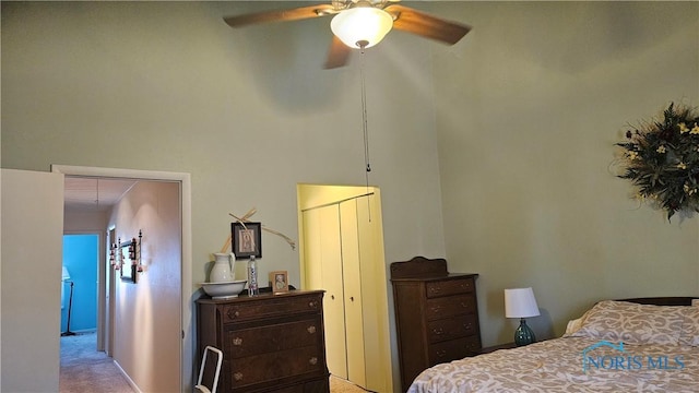 bedroom with a ceiling fan, carpet flooring, and a high ceiling