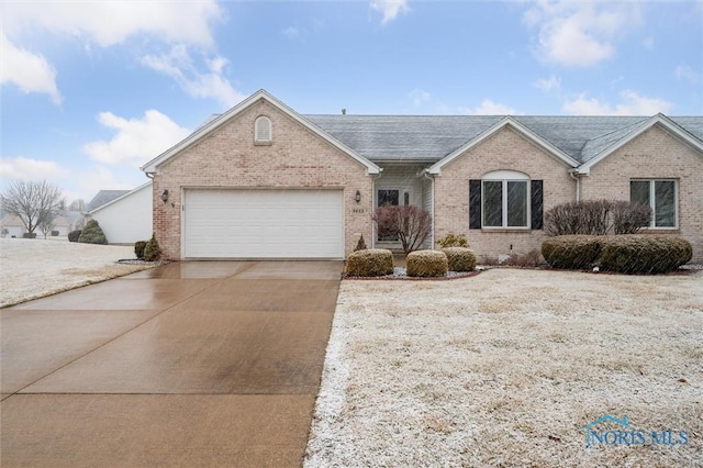 ranch-style home featuring concrete driveway, brick siding, roof with shingles, and an attached garage