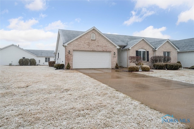 single story home featuring driveway, brick siding, an attached garage, and a shingled roof