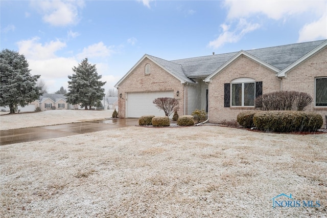 single story home featuring concrete driveway, brick siding, and an attached garage