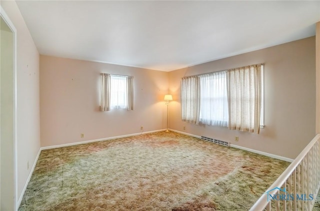 empty room featuring baseboards, visible vents, and carpet flooring