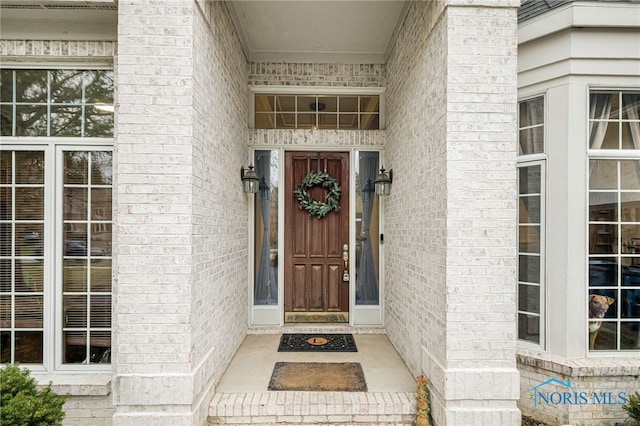 doorway to property featuring brick siding