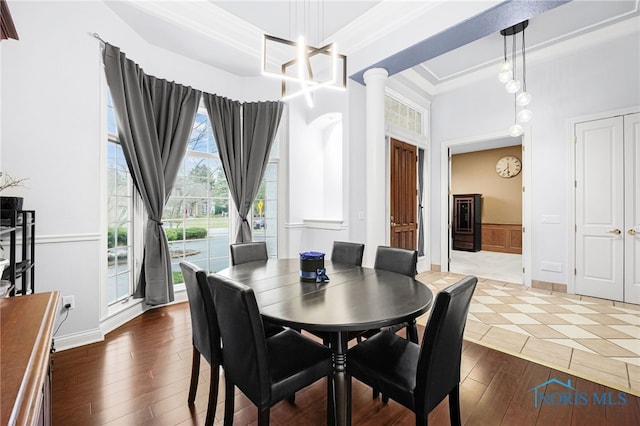 dining room featuring ornate columns and wood finished floors