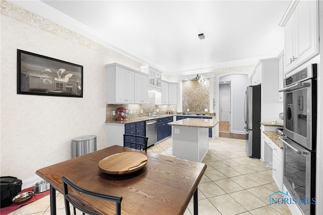 dining area featuring light tile patterned flooring, baseboards, crown molding, and arched walkways