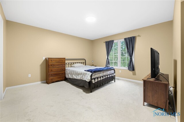 bedroom with baseboards and light colored carpet