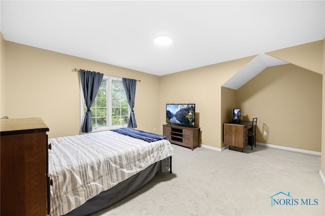 carpeted bedroom featuring baseboards and lofted ceiling