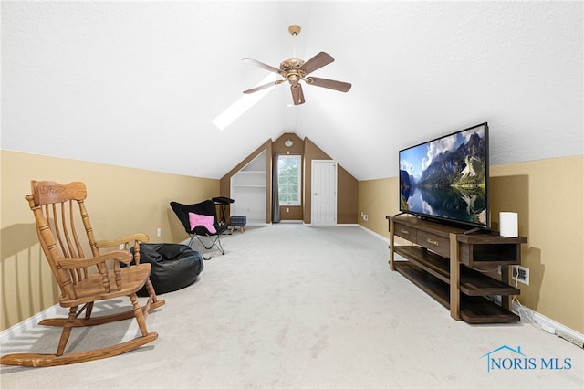 living area with a ceiling fan, carpet, lofted ceiling, and baseboards